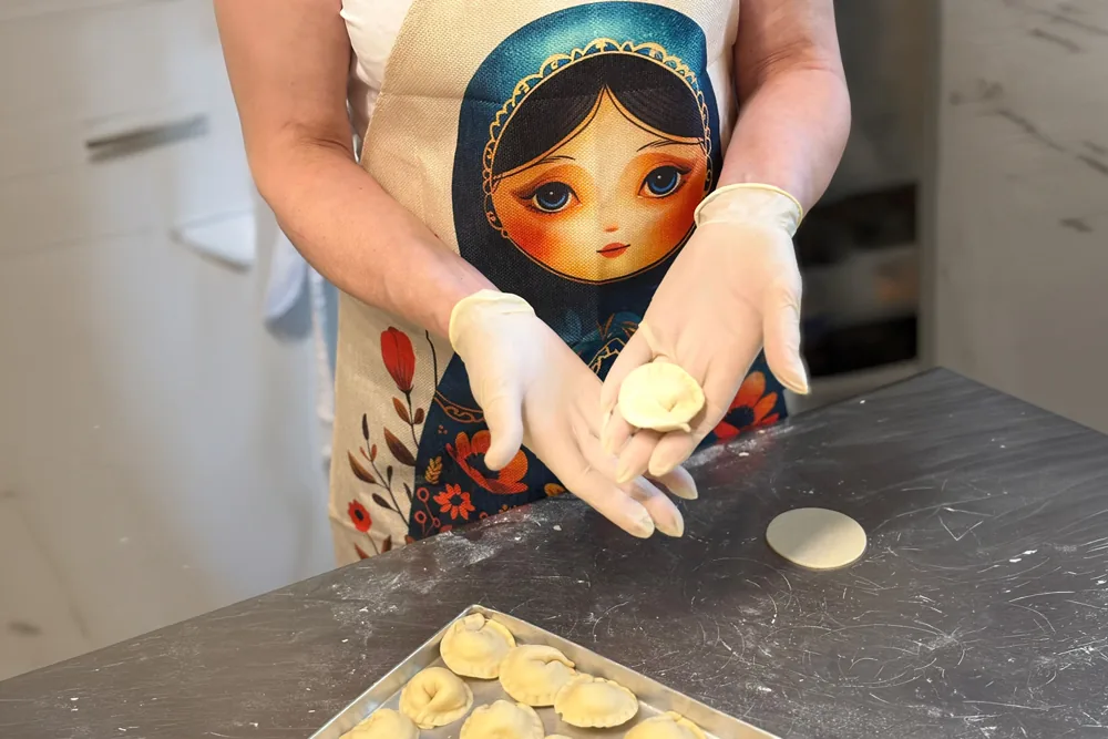 Hände formen frische Pelmeni in der Küche des Restaurants Mamuschka in Minden